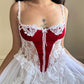 Frederick’s stunning bridal-inspired sheer slip dress featuring crimson red velvet bustier patch detail